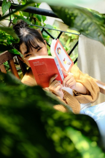A parent reviewing a weekly schedule on a tablet while children work at a table nearby