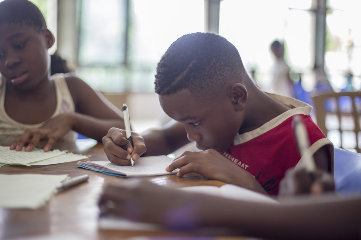 Children focused on writing and studying at a desk