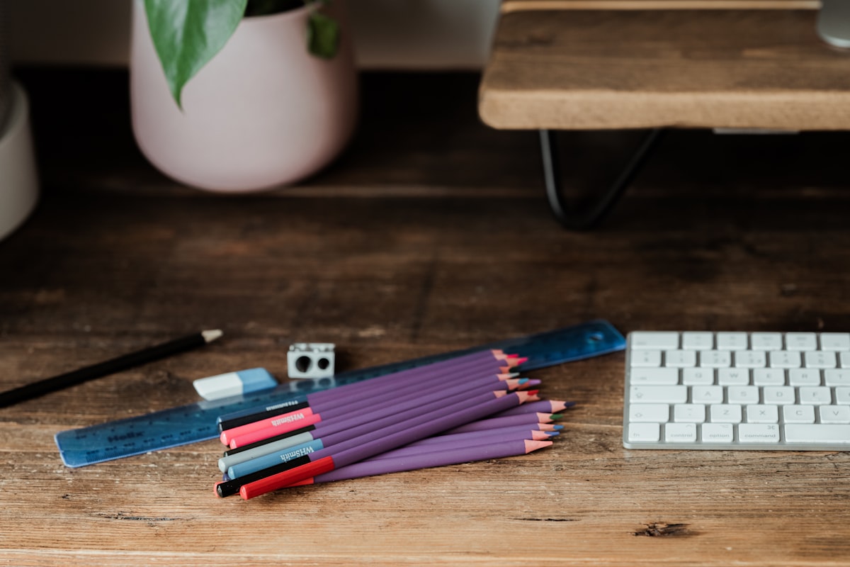 Learning supplies including colored pencils and rulers on a wooden desk