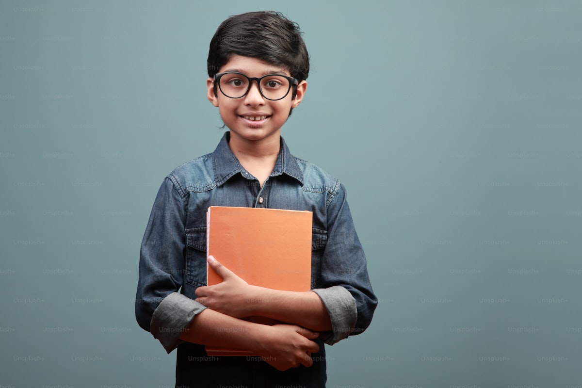 A confident young student holding a notebook and smiling