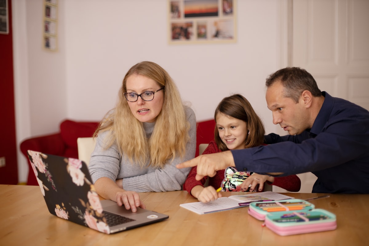Parents helping their child with learning activities at a desk