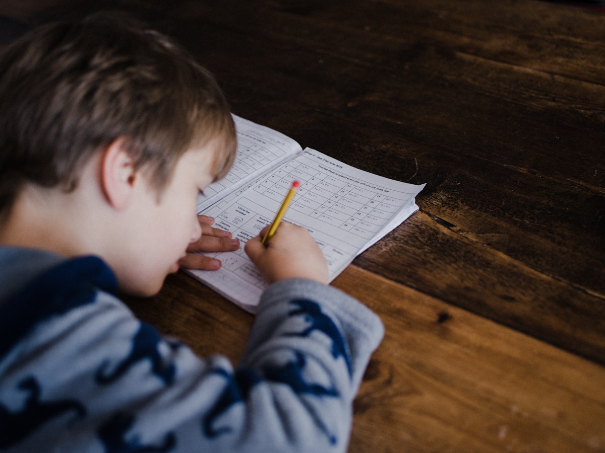 A young boy working on math problems with a pencil