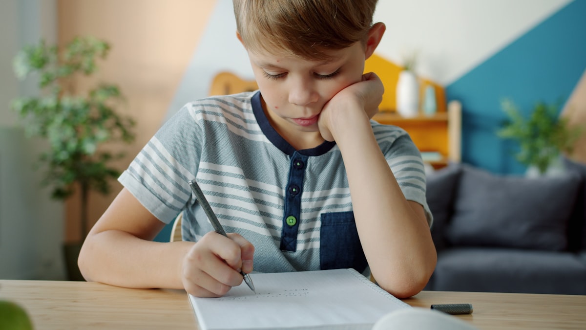 A child completing a reading worksheet at a desk with pencils